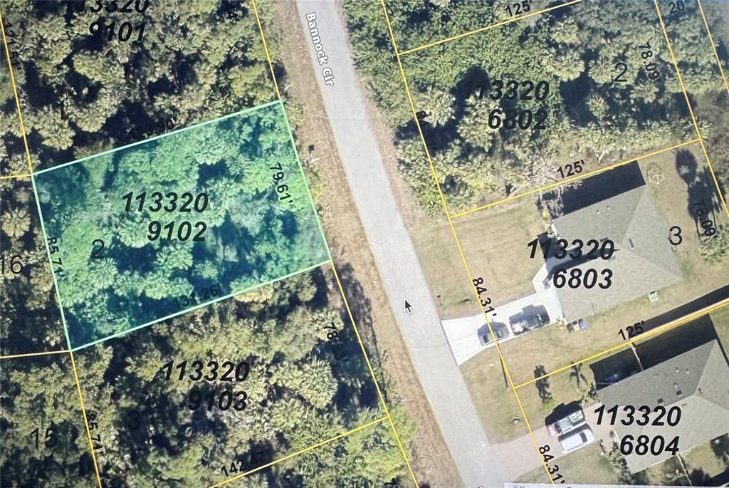This is an aerial map showing a vacant, wooded residential lot highlighted in green — BANNOCK CIRCLE, NORTH PORT, FL