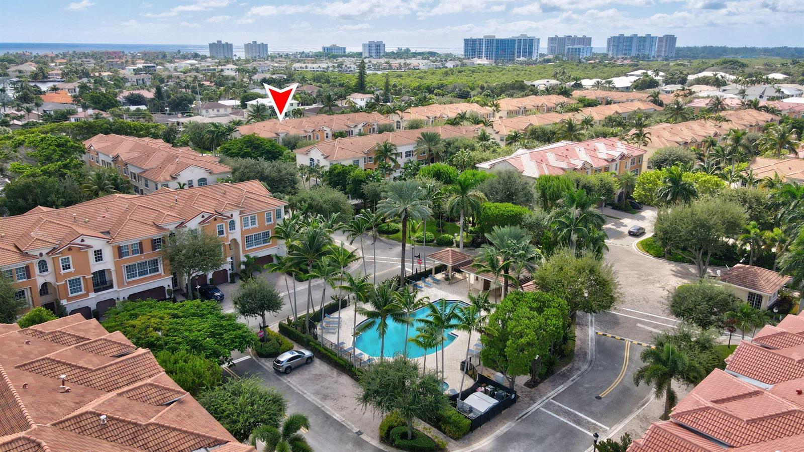 An aerial view of a residential complex featuring townhomes, a swimming pool, and palm trees — 5660 NE Trieste Way, Boca Raton FL 33487, BOCA RATON, FL
