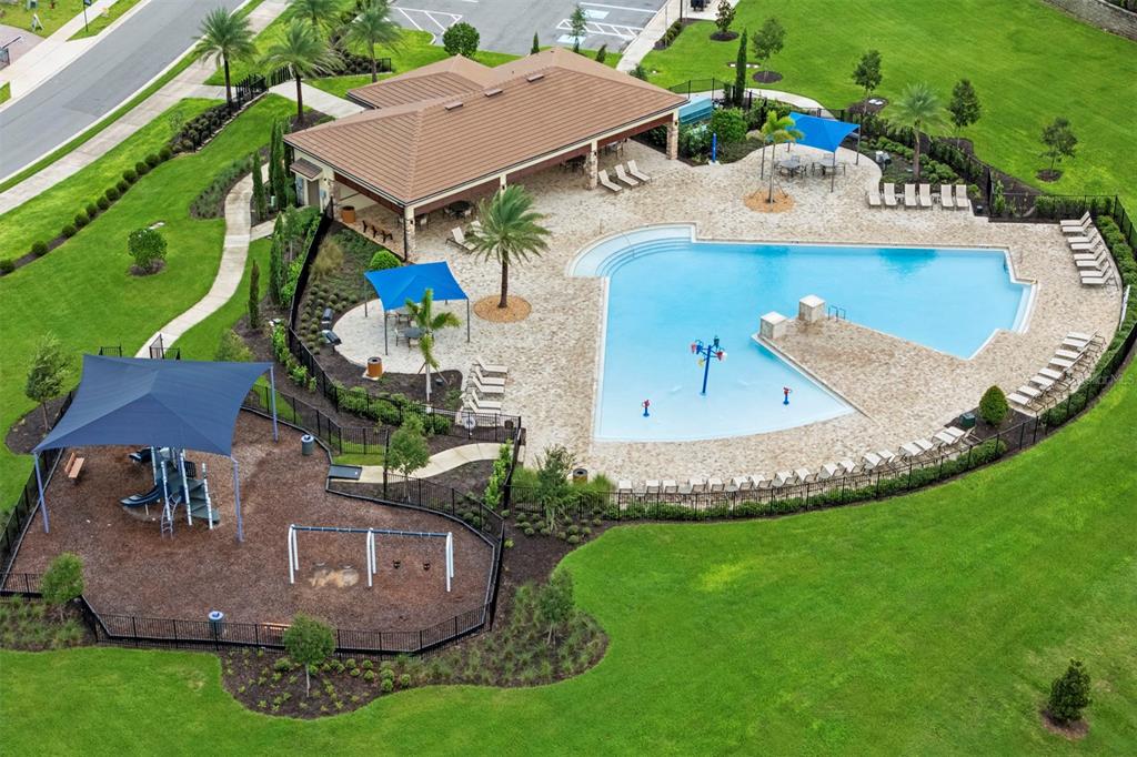 An aerial view shows a community swimming pool, a playground, and a covered clubhouse — 7500 CATANIA LOOP, CLERMONT, FL