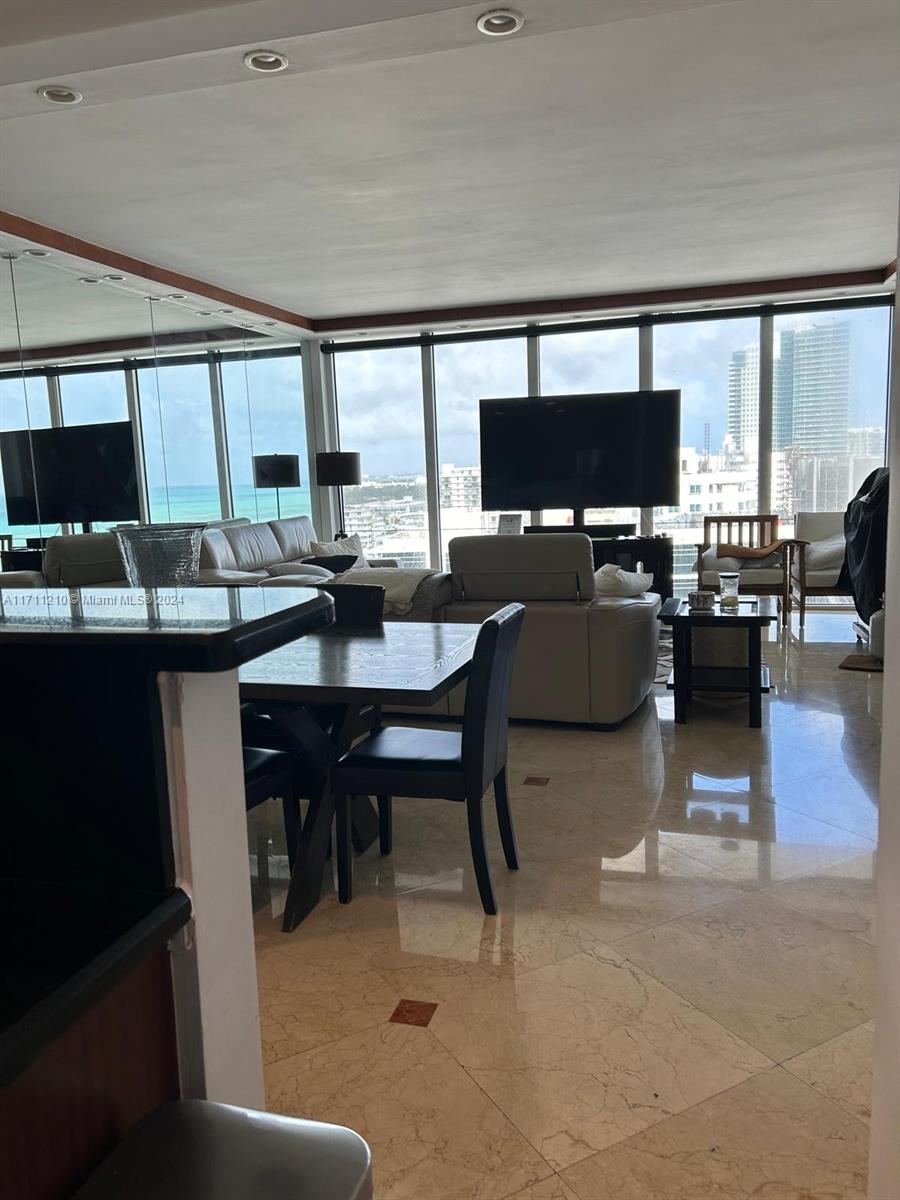 A living and dining area features marble floors, floor-to-ceiling windows, and ocean views — 100 Lincoln Rd, Miami Beach FL 33139, MIAMI BEACH, FL