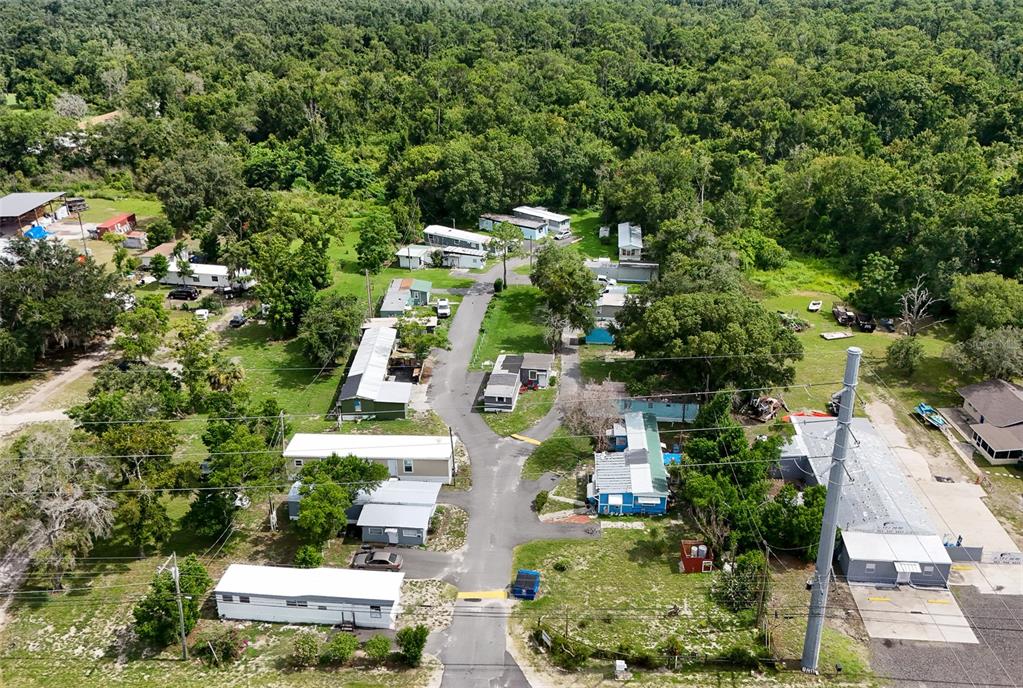 An aerial view shows a mobile home park surrounded by dense trees and vegetation — 340 RECKER HIGHWAY, AUBURNDALE, FL