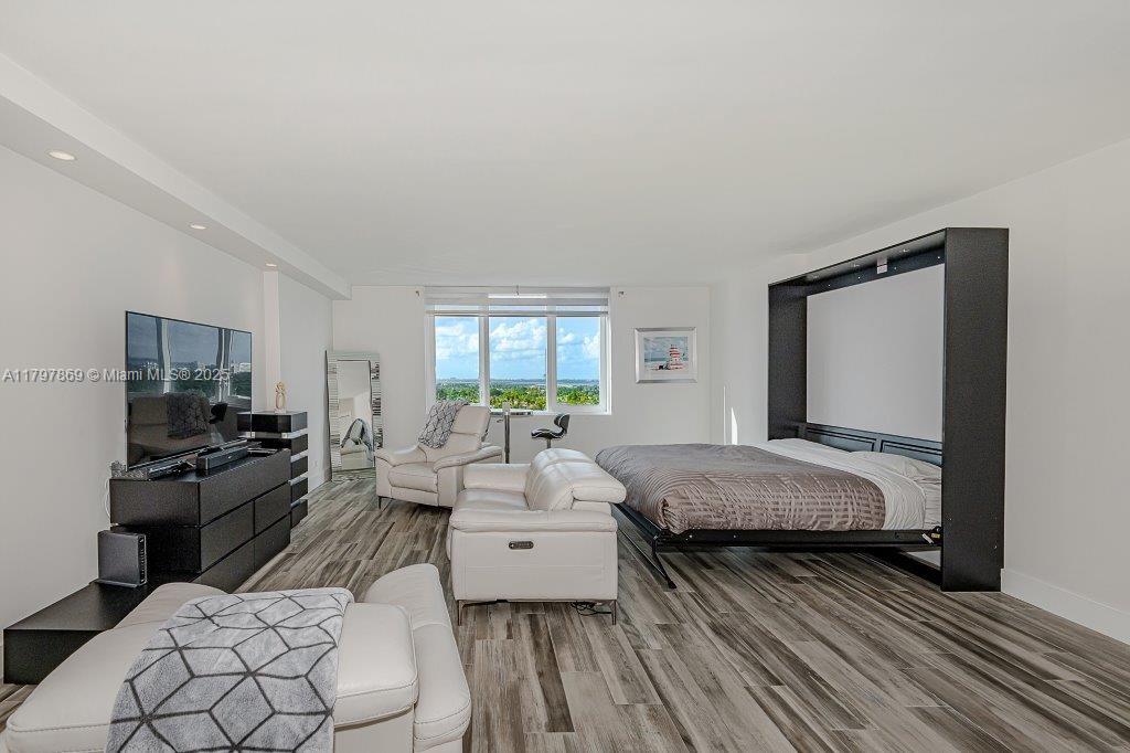 This room features a Murphy bed, white leather furniture, a television console, and wood flooring — 2301 Collins Ave # 1532, Miami Beach FL 33139, MIAMI BEACH, FL