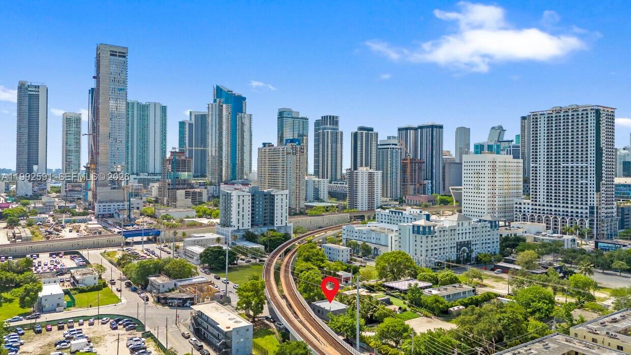 An aerial view shows a small building marked with a red pin near elevated train tracks — 212 NW 11th St, Miami FL 33136, MIAMI, FL