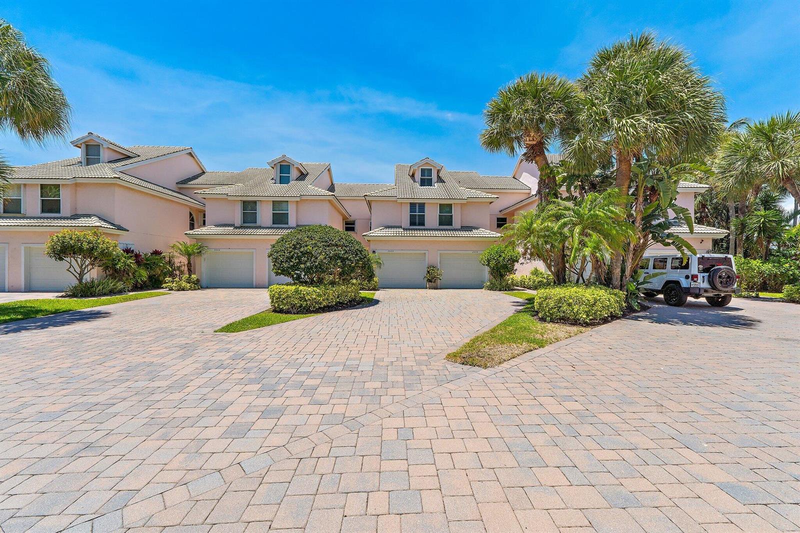 A multi-unit residential building with a paved driveway, palm trees, and a parked SUV — 2605 N Fairway Dr Drive N, Jupiter FL 33477, JUPITER, FL