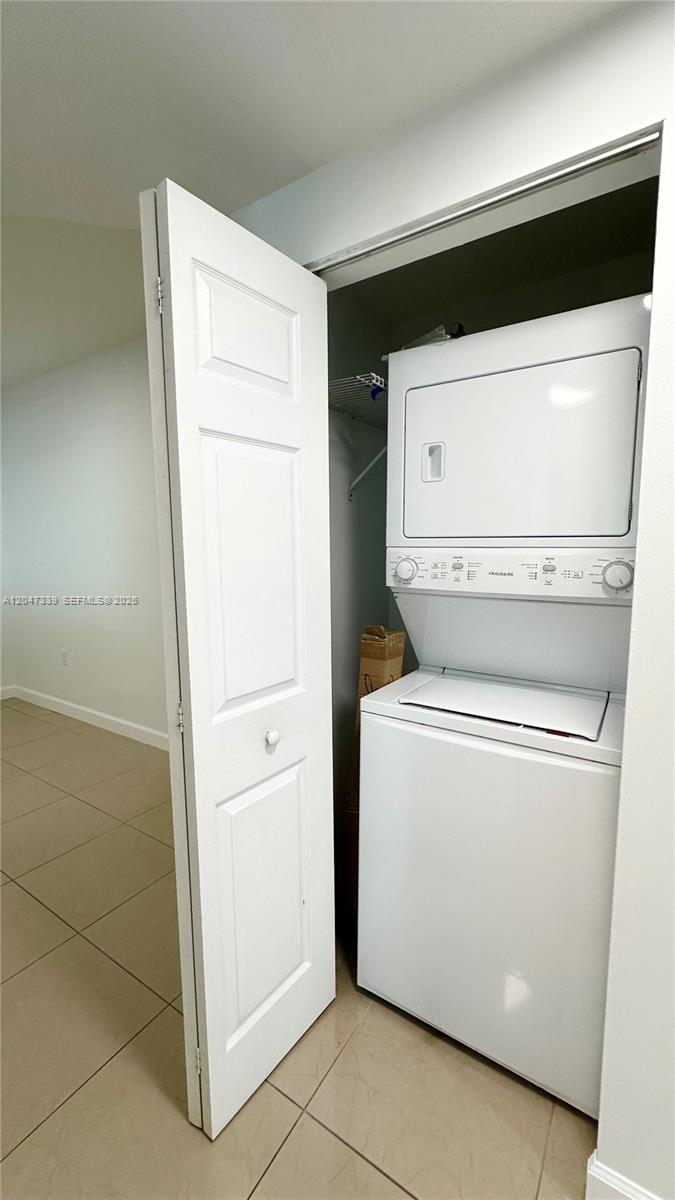 A white stacked washer and dryer unit is located inside a closet with tile flooring — 140 S Dixie Hwy # 808, Hollywood FL 33020, HOLLYWOOD, FL