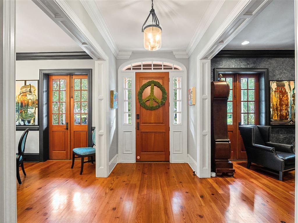 A foyer with hardwood floors, a central wooden door, and two side rooms with glass doors — 1600 LEGION DRIVE, WINTER PARK, FL