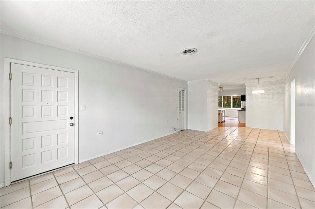 An empty room with light-colored tile flooring, white walls, and a white front door — 1342 SNELL ISLE BOULEVARD NE UNIT 4, ST PETERSBURG, FL