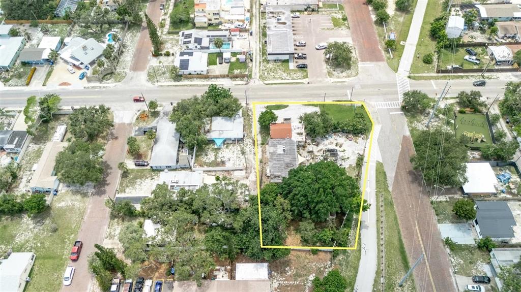 This aerial view shows a residential lot outlined in yellow with a house and trees — 500 64TH STREET S, ST PETERSBURG, FL