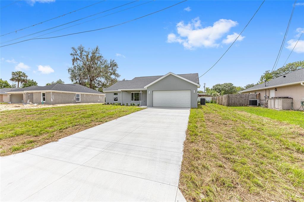A single-story gray house with a white garage door and a concrete driveway — 654 NE 130TH COURT, SILVER SPRINGS, FL