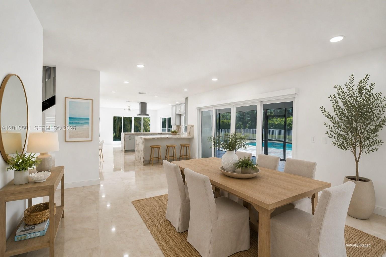 A dining area with a wooden table and chairs opens to a kitchen and pool patio — 4024 Frances Dr, Delray Beach FL 33445, DELRAY BEACH, FL