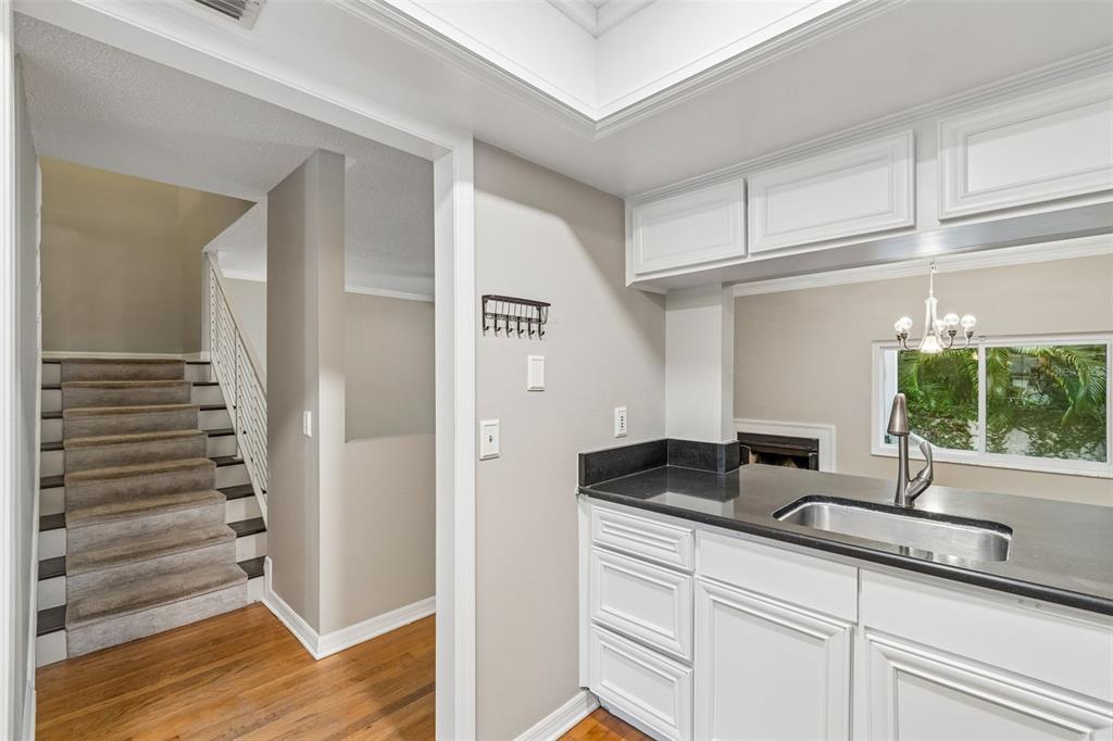 A view through a kitchen pass-through window into a kitchen with white cabinets and appliances — 5203 BAYSHORE BOULEVARD UNIT 5, TAMPA, FL