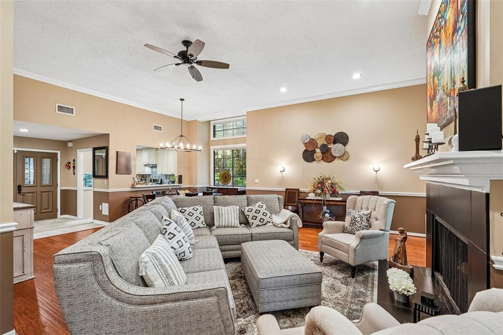 A living room features a large sectional sofa, fireplace, and hardwood floors — 5676 PIPERS WAITE UNIT 56, SARASOTA, FL