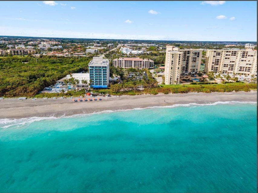 An aerial view shows beachfront hotels and resorts along a coastline with turquoise water — 500 Ocean Trail Way # 409, Jupiter FL 33477, JUPITER, FL