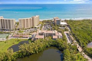 An aerial view shows beachfront high-rise condominiums, a smaller complex, and a pond — 500 Ocean Trail Way # 409, Jupiter FL 33477, JUPITER, FL