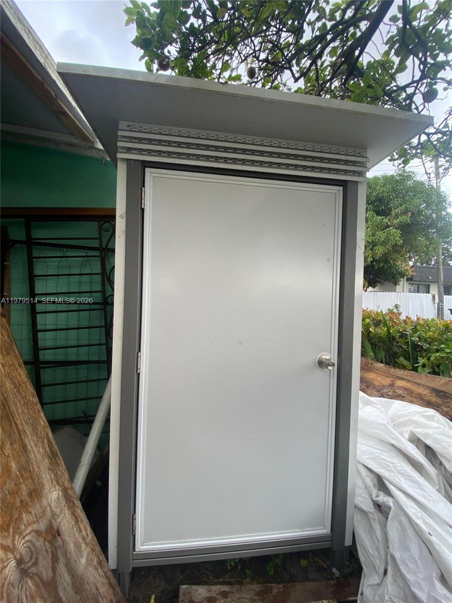 A white exterior door is set within a simple frame under a small roof overhang — 2239 Sheridan St, Hollywood FL 33020, HOLLYWOOD, FL
