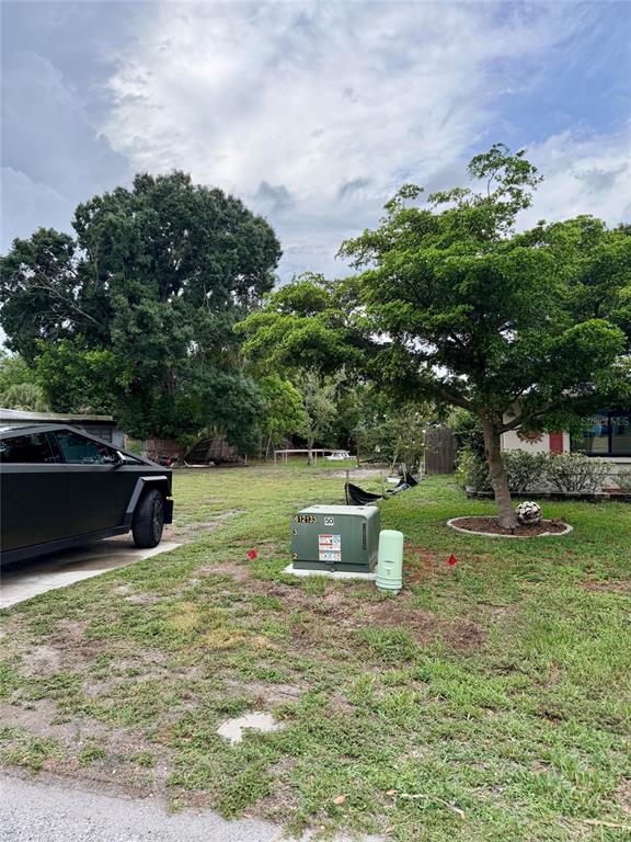 A black truck is parked on a driveway next to a grassy yard with utility boxes — 2101 ROSE STREET, SARASOTA, FL