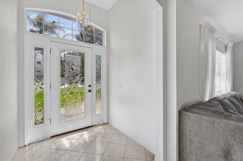 An entryway features a white front door with decorative glass panels and tiled flooring — 1 WELLWATER DRIVE, PALM COAST, FL