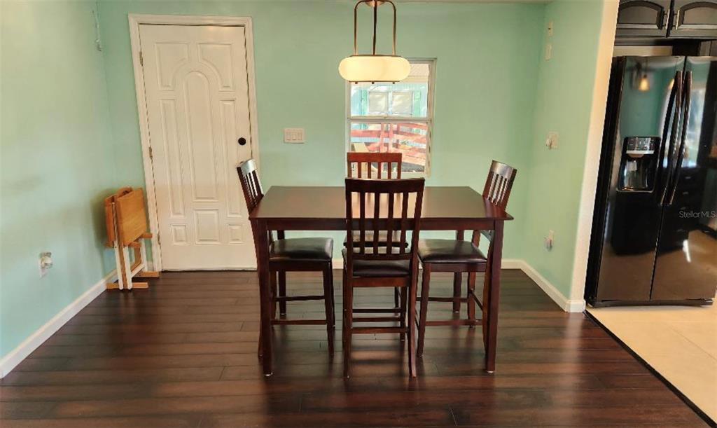 A dining room features dark wood furniture, hardwood floors, and light green walls — 6371 FRANK COURT, BROOKSVILLE, FL