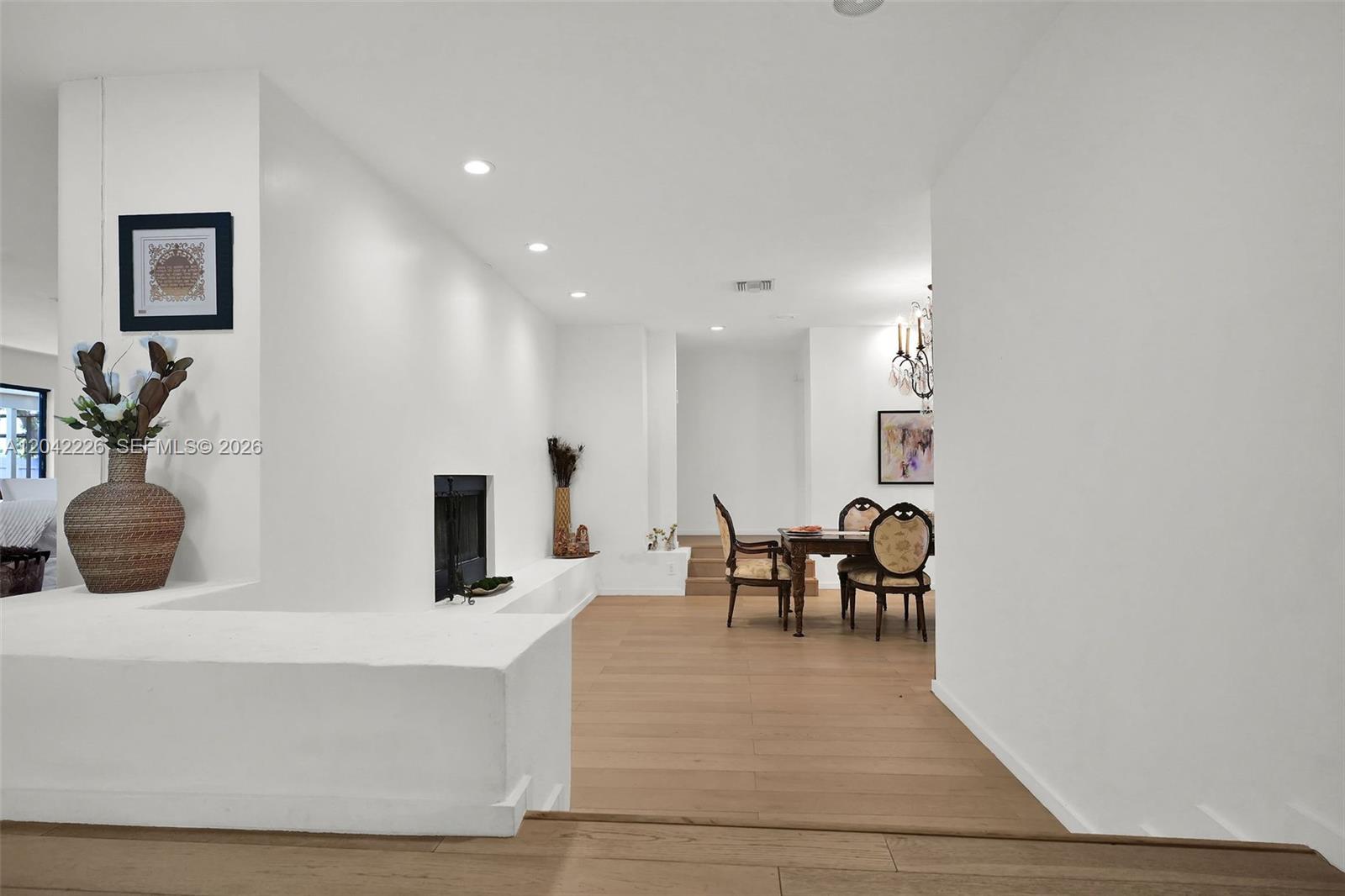 A bright dining area features a fireplace, light wood flooring, and white walls — 5801 SW 37th Ter, Dania Beach FL 33312, DANIA BEACH, FL