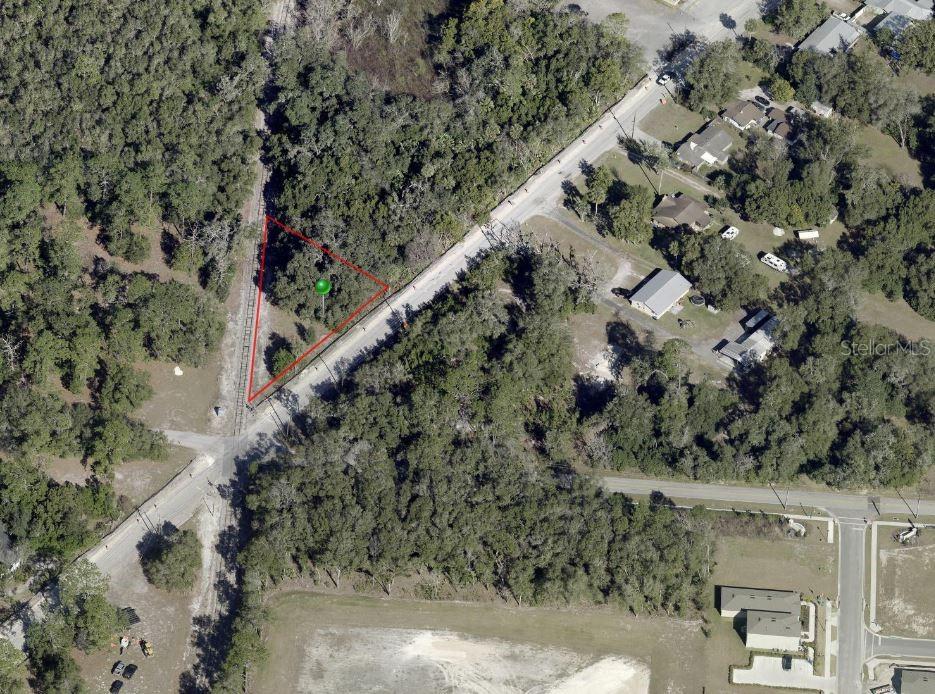 An aerial view shows a triangular plot of land outlined in red near a road — OLD NEW YORK AVENUE, DELAND, FL