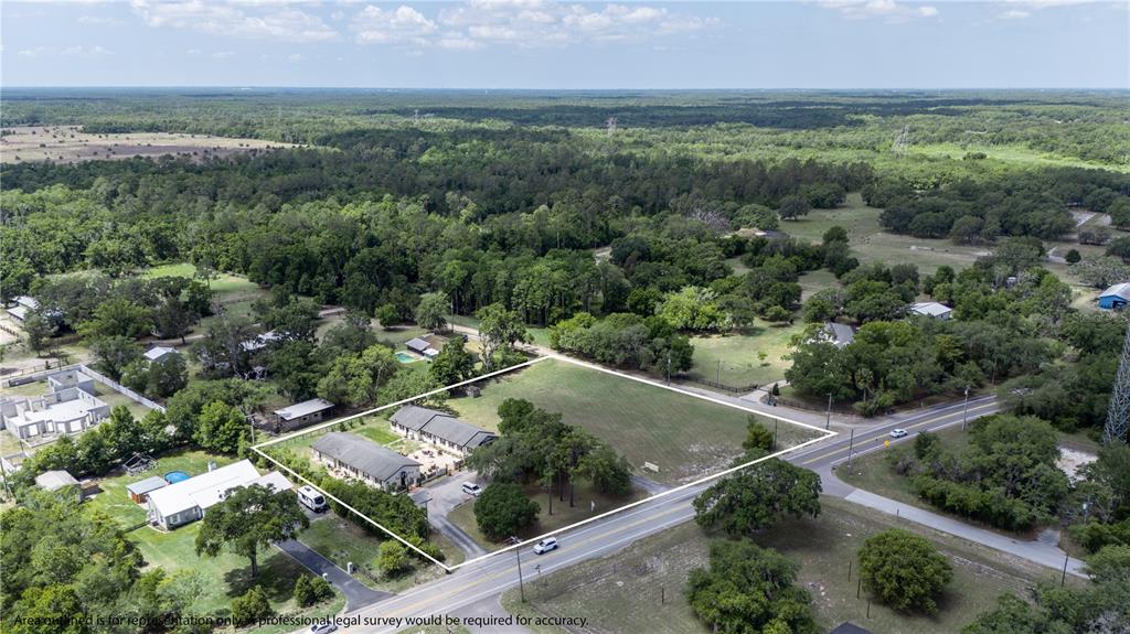 An aerial view shows a property with a building and open land along a road — 13042 TARPON SPRINGS ROAD, ODESSA, FL