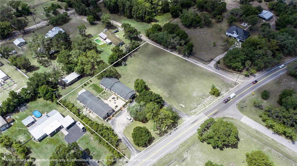 An aerial view shows a rectangular lot with two buildings and a large grassy area — 13042 TARPON SPRINGS ROAD, ODESSA, FL