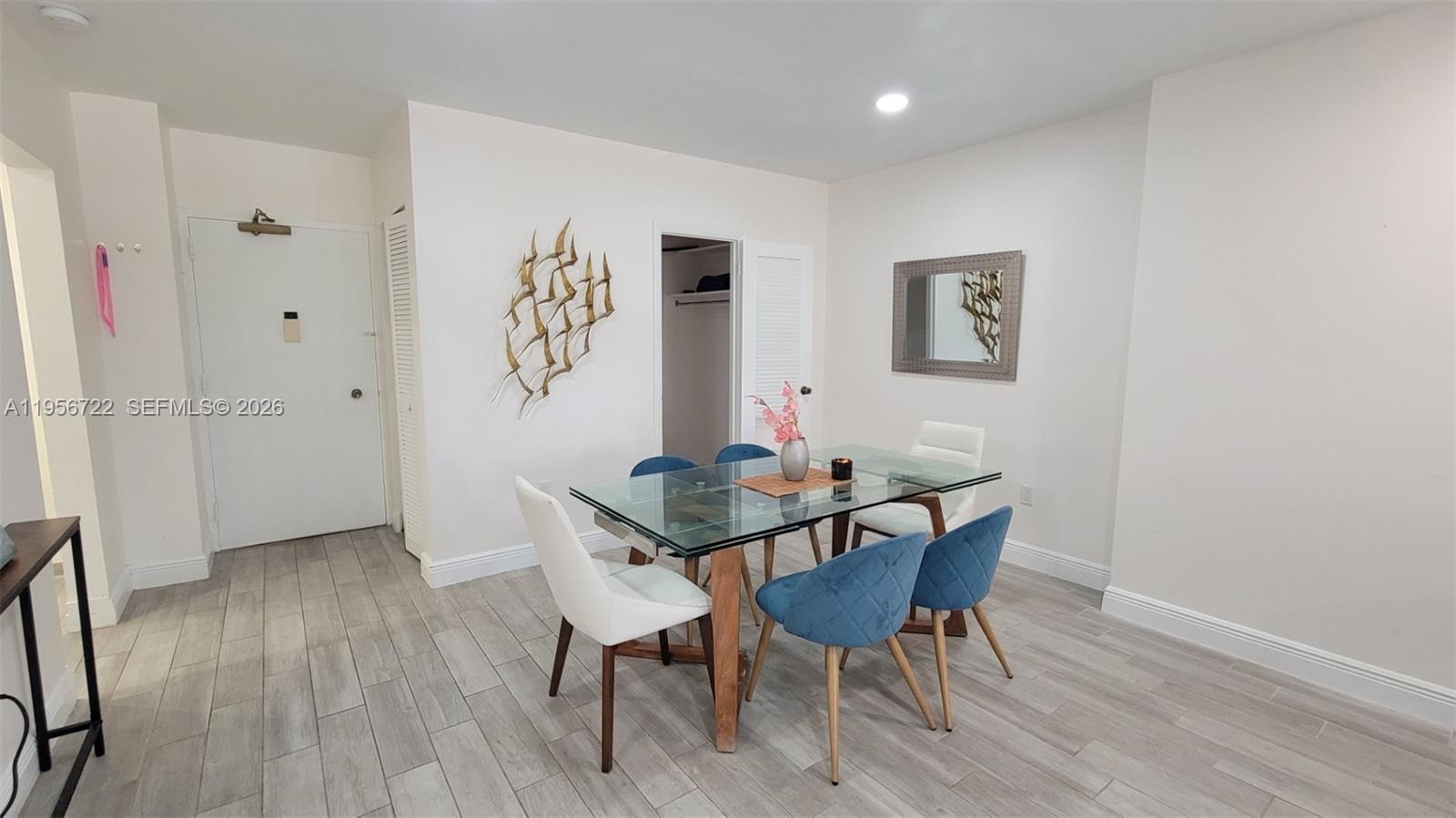 A dining area features a glass-topped table, mixed-style chairs, and light wood-look tile flooring — 1965 S Ocean Dr, Hallandale Beach FL 33009, HALLANDALE BEACH, FL