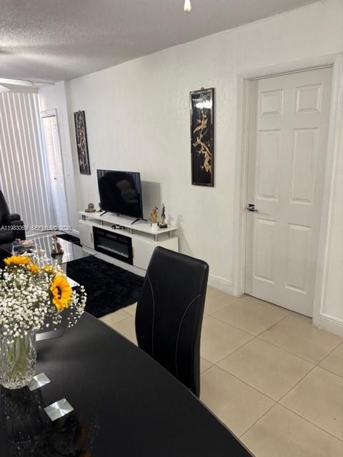 A dining area features a black table and chair, a television console, and a white door — 1750 W 56 st # 112, Hialeah FL 33012, HIALEAH, FL