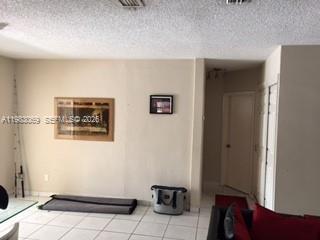 A living room with light-colored tile floors, a framed picture, and a doorway leading inside — 1750 W 56 st # 112, Hialeah FL 33012, HIALEAH, FL