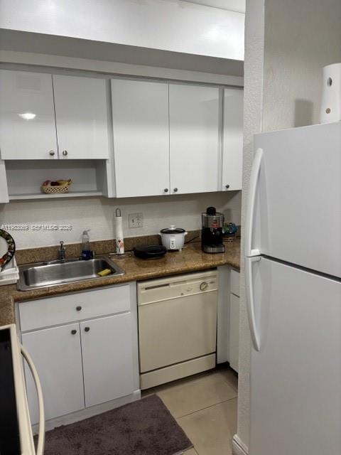 A kitchen features white cabinets, a stainless steel sink, a dishwasher, and a white refrigerator — 1750 W 56 st # 112, Hialeah FL 33012, HIALEAH, FL