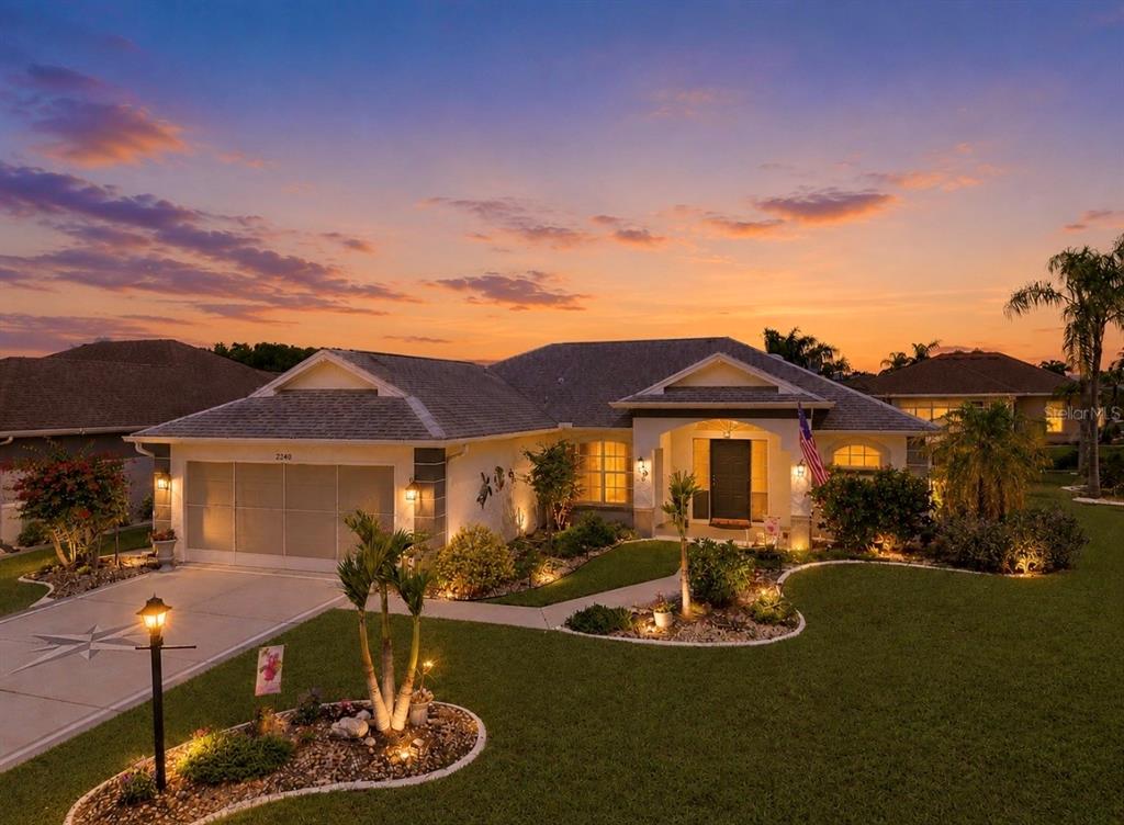 A single-story house with a two-car garage and landscaped yard at sunset — 2240 W DEL WEBB BOULEVARD UNIT 163, SUN CITY CENTER, FL