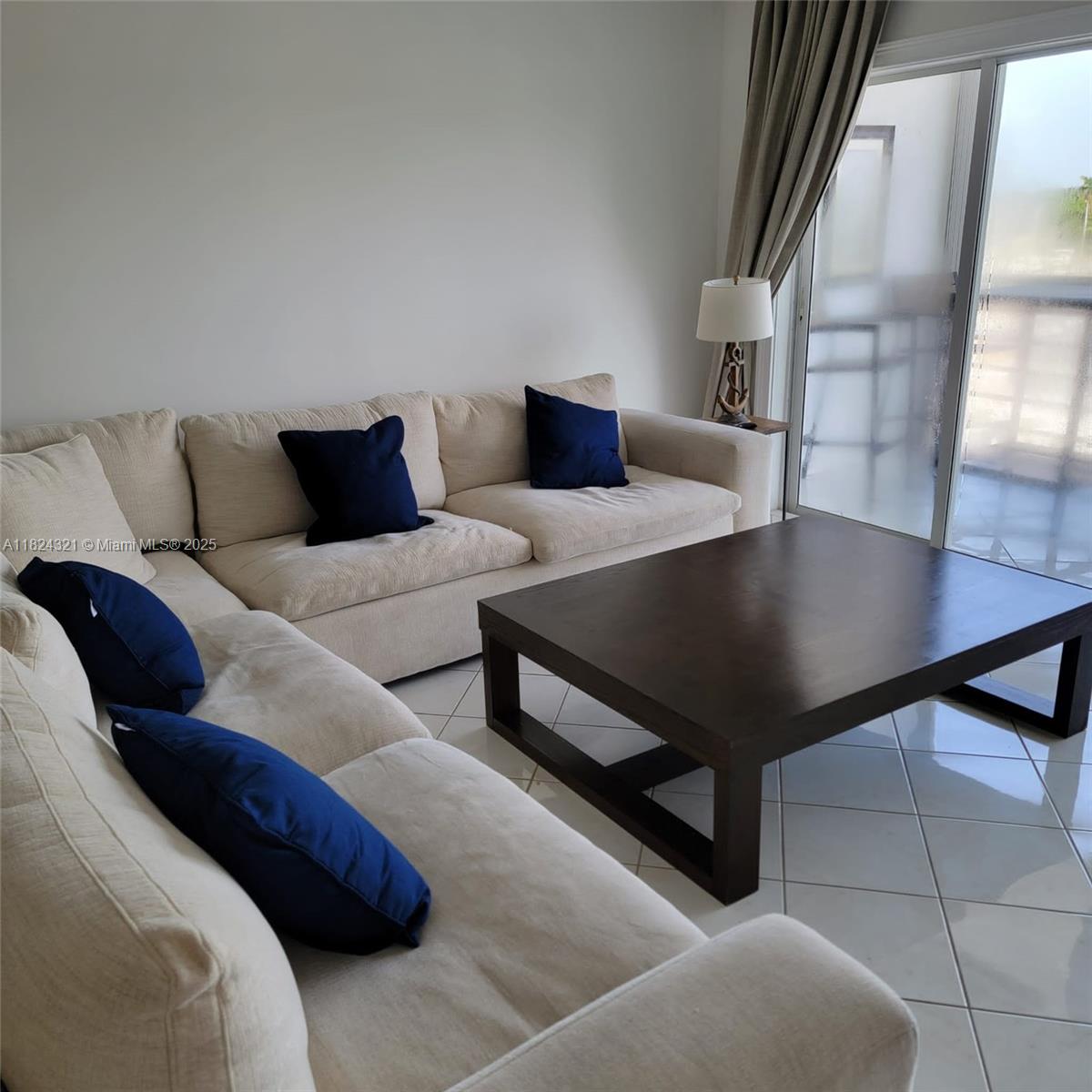 A living room features a beige sectional sofa, dark blue pillows, and a dark wooden coffee table — 2731 NE 14th St Cswy # 636, Pompano Beach FL 33062, POMPANO BEACH, FL