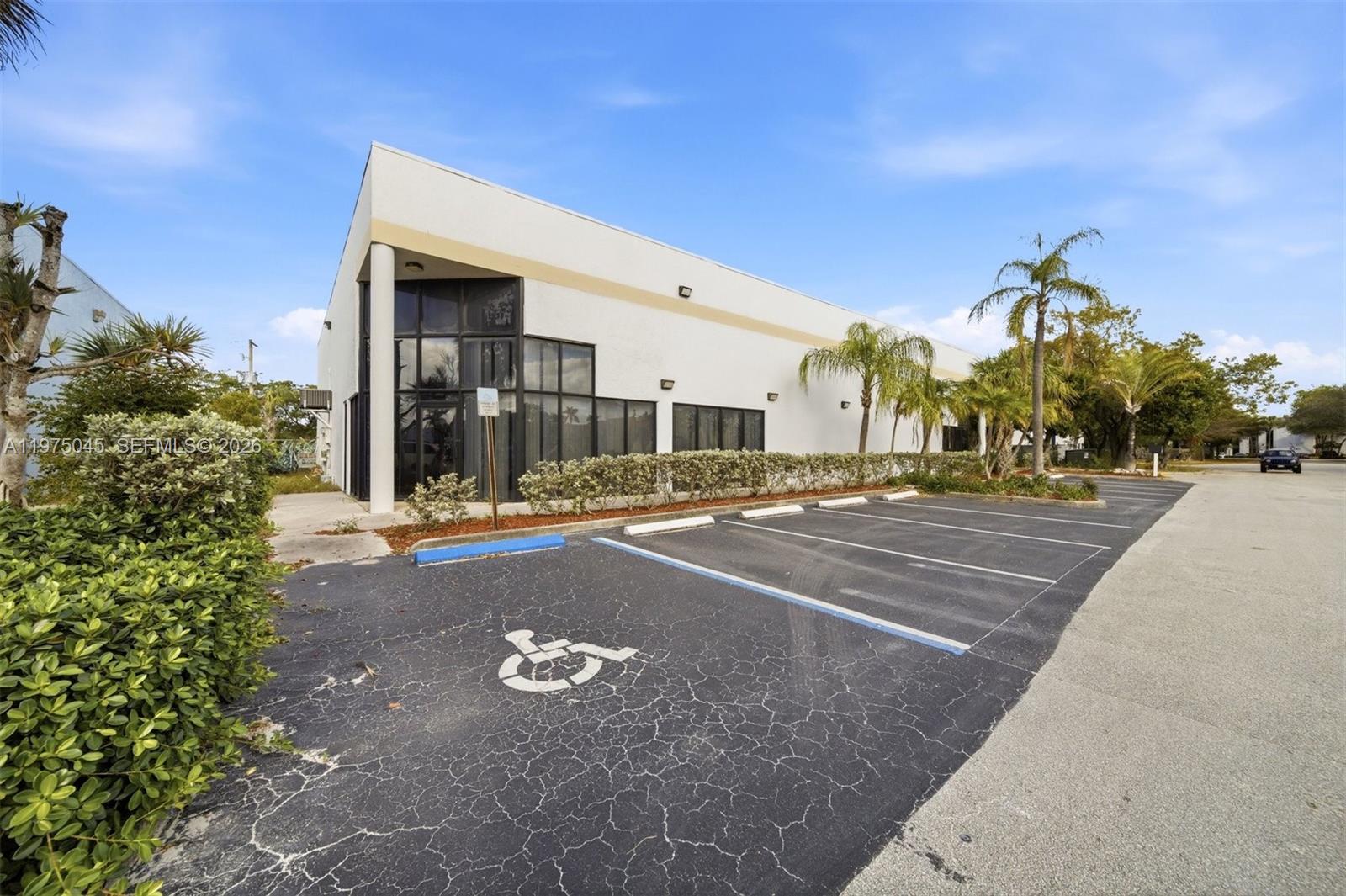 A single-story commercial building with a glass-front entrance and a paved parking lot — 2891 NW 22nd Ter, Pompano Beach FL 33069, POMPANO BEACH, FL