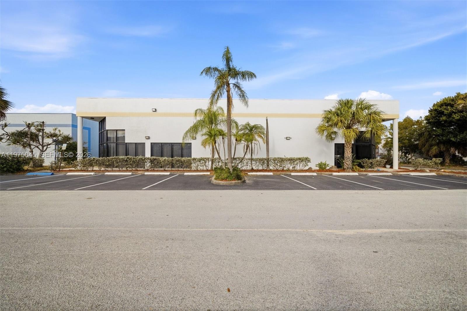 A single-story commercial building with a parking lot and palm trees in front — 2891 NW 22nd Ter, Pompano Beach FL 33069, POMPANO BEACH, FL