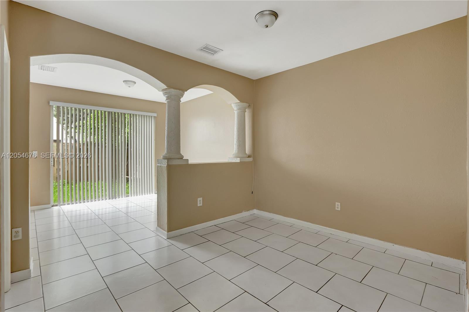 A room with white tile floors, beige walls, and a partial wall with decorative columns — 2874 SE 15th Rd # 52, Homestead FL 33035, HOMESTEAD, FL
