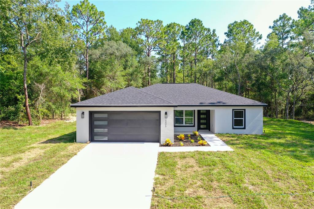 An open-concept living room and kitchen featuring a sectional sofa, dining area, and island — 22575 SW ANCHOR BOULEVARD, DUNNELLON, FL