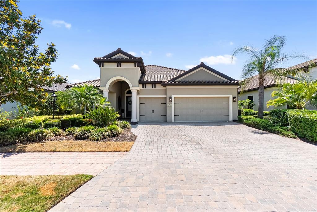 A single-story house with a tiled roof, two-car garage, and a paved driveway — 16512 BERWICK TERRACE, BRADENTON, FL