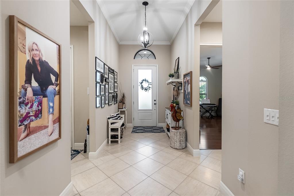 A bright entryway features tile flooring, a white front door, and a gallery wall — 16512 BERWICK TERRACE, BRADENTON, FL