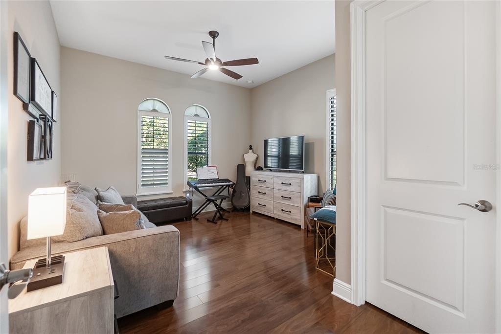 A living room features hardwood floors, a gray sofa, a keyboard, and a white dresser — 16512 BERWICK TERRACE, BRADENTON, FL