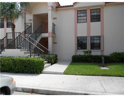 Exterior view of a two-story apartment building with a concrete staircase and landscaped bushes — 3180 Leewood Terrace # L108, Boca Raton FL 33431, BOCA RATON, FL