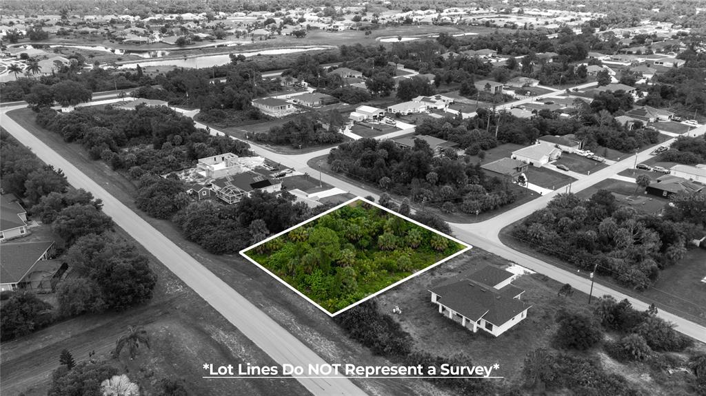 An aerial view shows a vacant, wooded residential lot outlined in white between two paved roads — ANDRIS STREET, NORTH PORT, FL