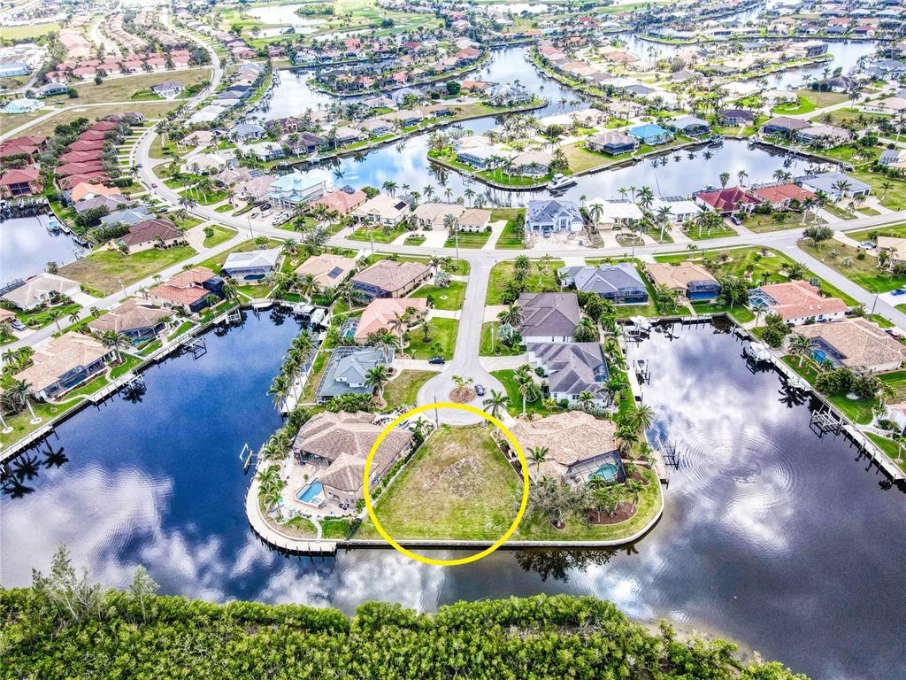 An aerial view shows a vacant waterfront residential lot circled in yellow — 3500 MARSALA COURT, PUNTA GORDA, FL
