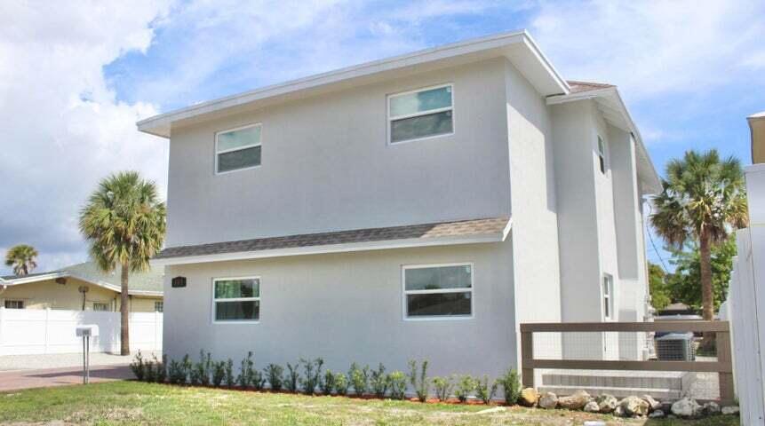 A two-story light gray house with a brown shingled roof and a wooden fence — 305 Cypress Drive # 1, Lake Park FL 33403, LAKE PARK, FL