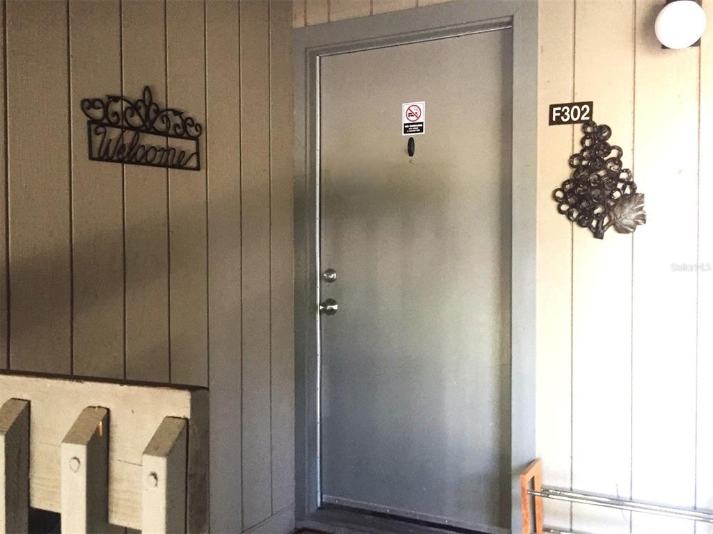A gray apartment door labeled F302 with a welcome sign and metal wall decor — 85 SE 16TH AVENUE UNIT F302, GAINESVILLE, FL