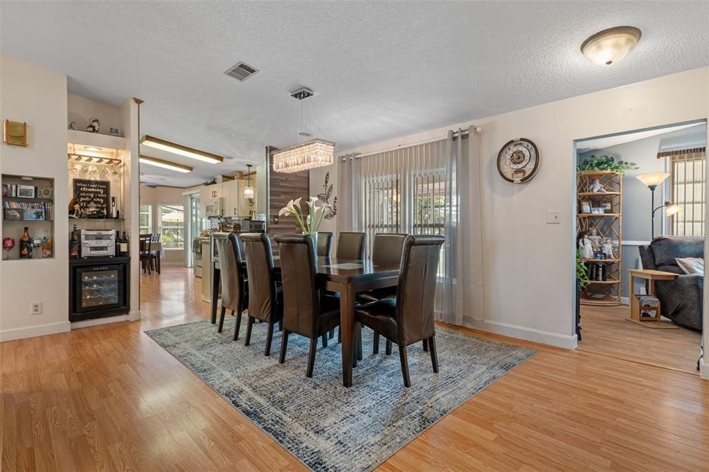 A dining room features a dark wood table, six chairs, a rug, and a built-in bar — 7436 NIELSON AVENUE, BROOKSVILLE, FL