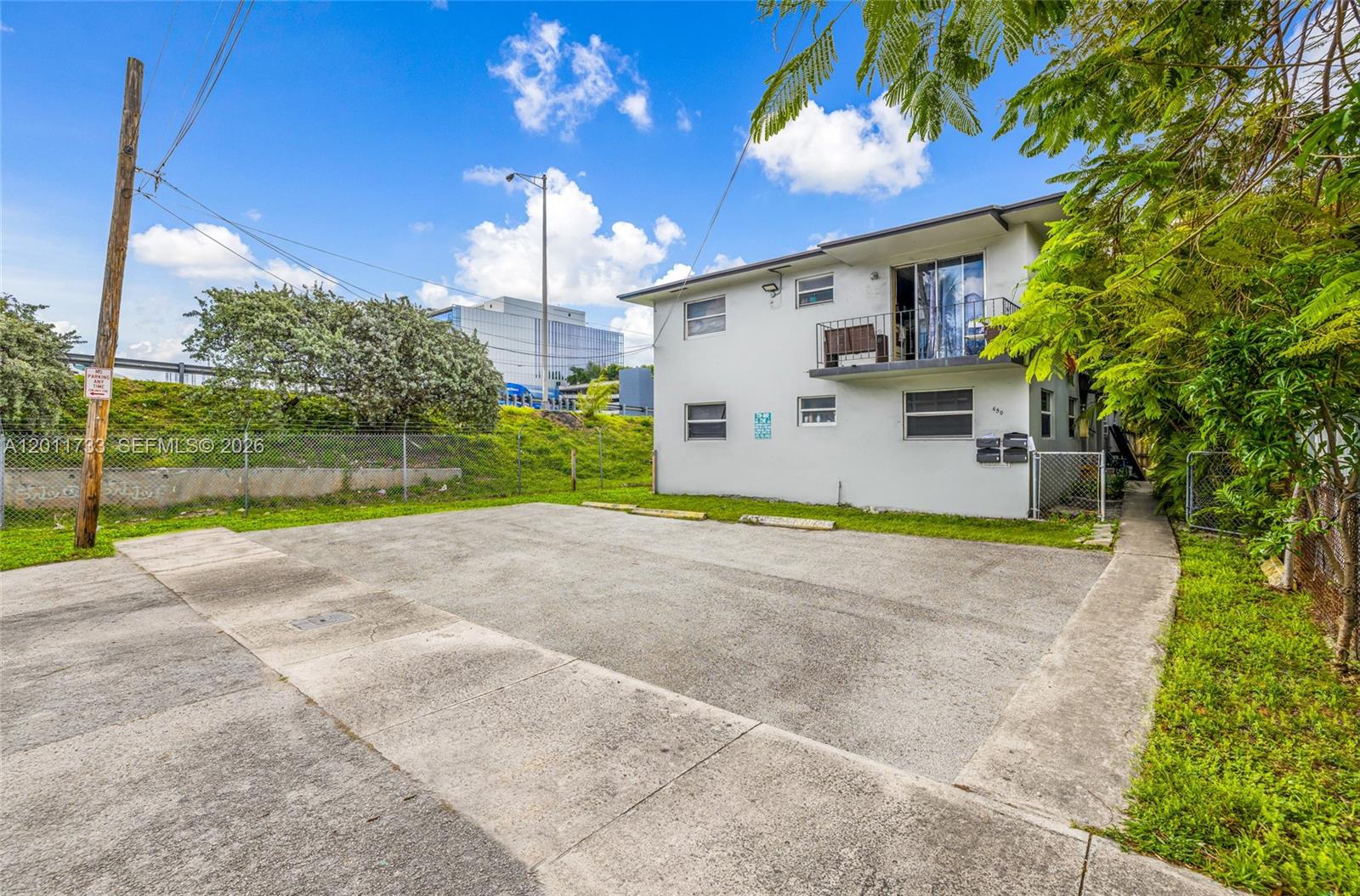 A two-story apartment building features a paved parking area and a small balcony — 650 NW 28th St, Miami FL 33127, MIAMI, FL
