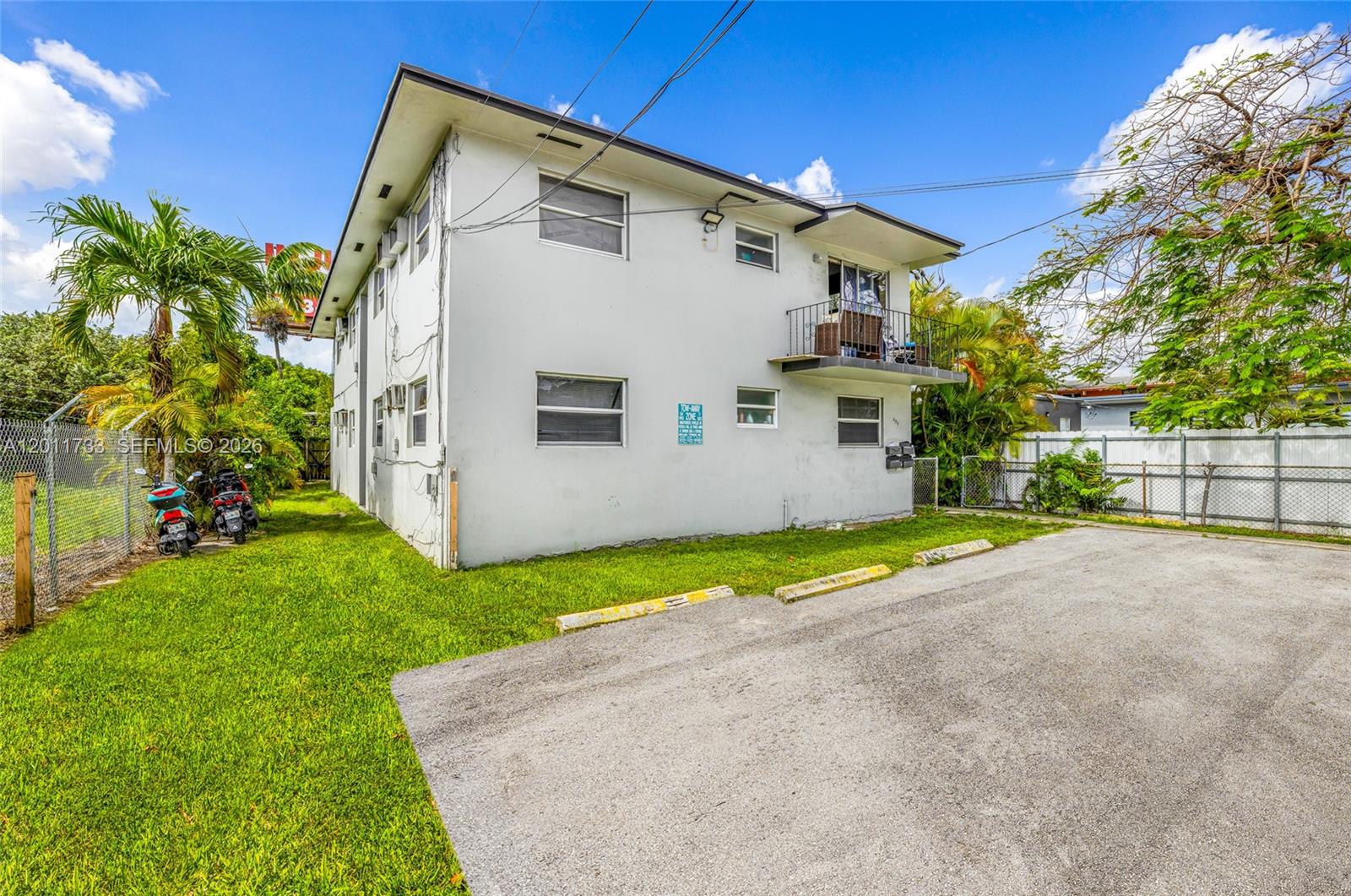 A two-story white apartment building with a small balcony and a paved parking area — 650 NW 28th St, Miami FL 33127, MIAMI, FL