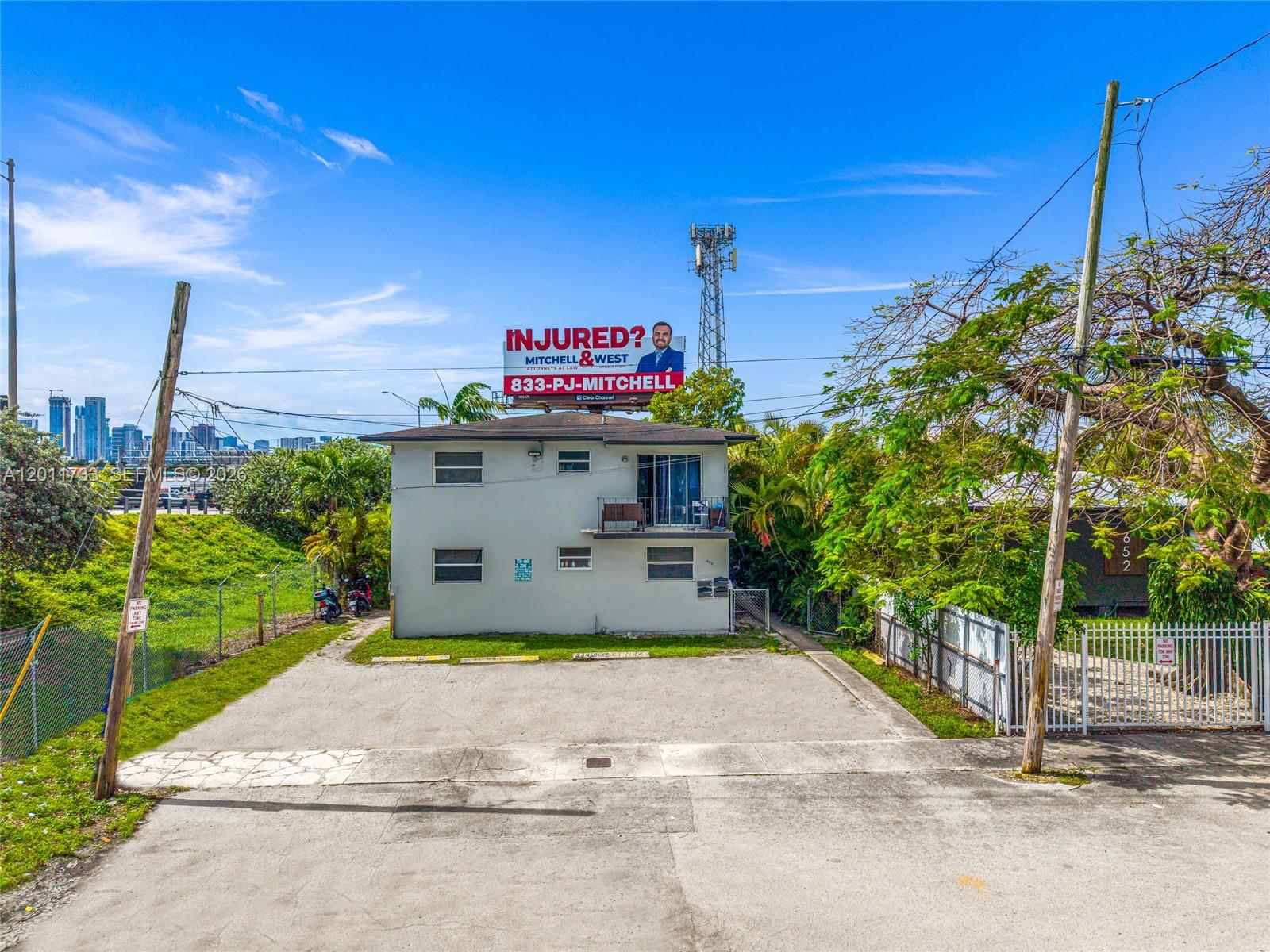 A two-story residential building with a billboard on the roof and a paved parking lot — 650 NW 28th St, Miami FL 33127, MIAMI, FL