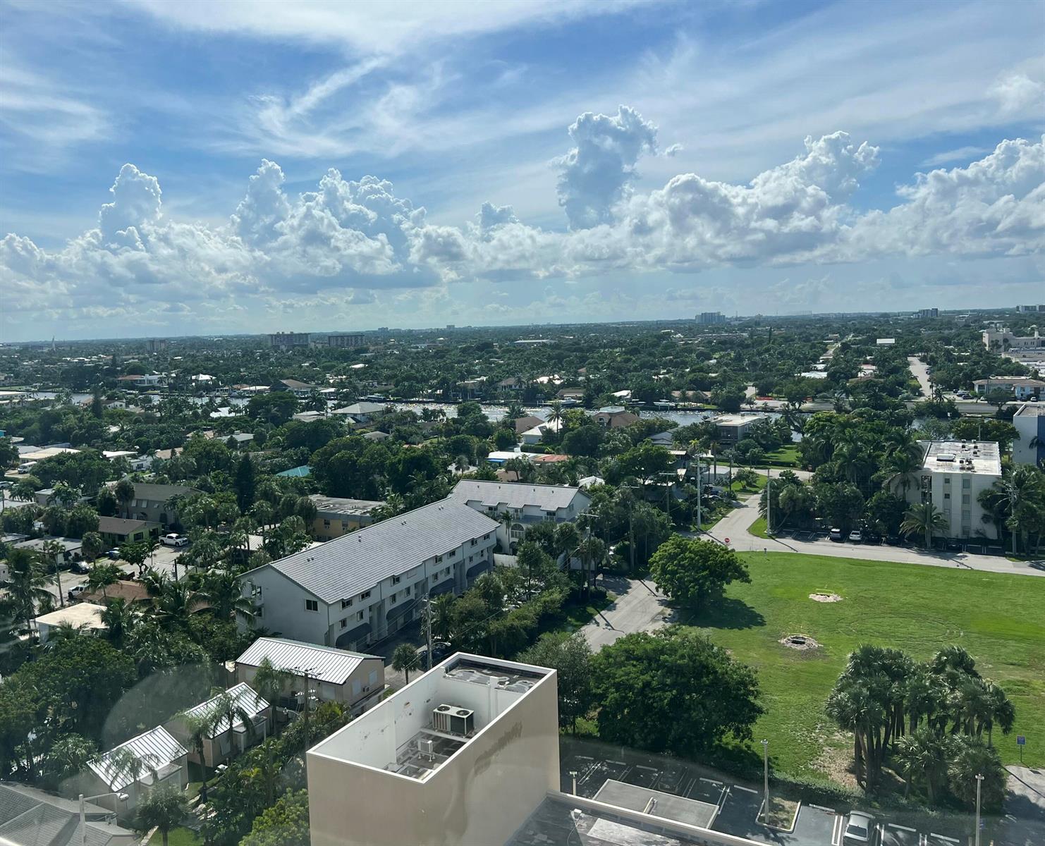 An elevated view of a suburban neighborhood with lush greenery, residential buildings, and cloudy skies — 111 Briny Avenue # 1511, Pompano Beach FL 33062, POMPANO BEACH, FL