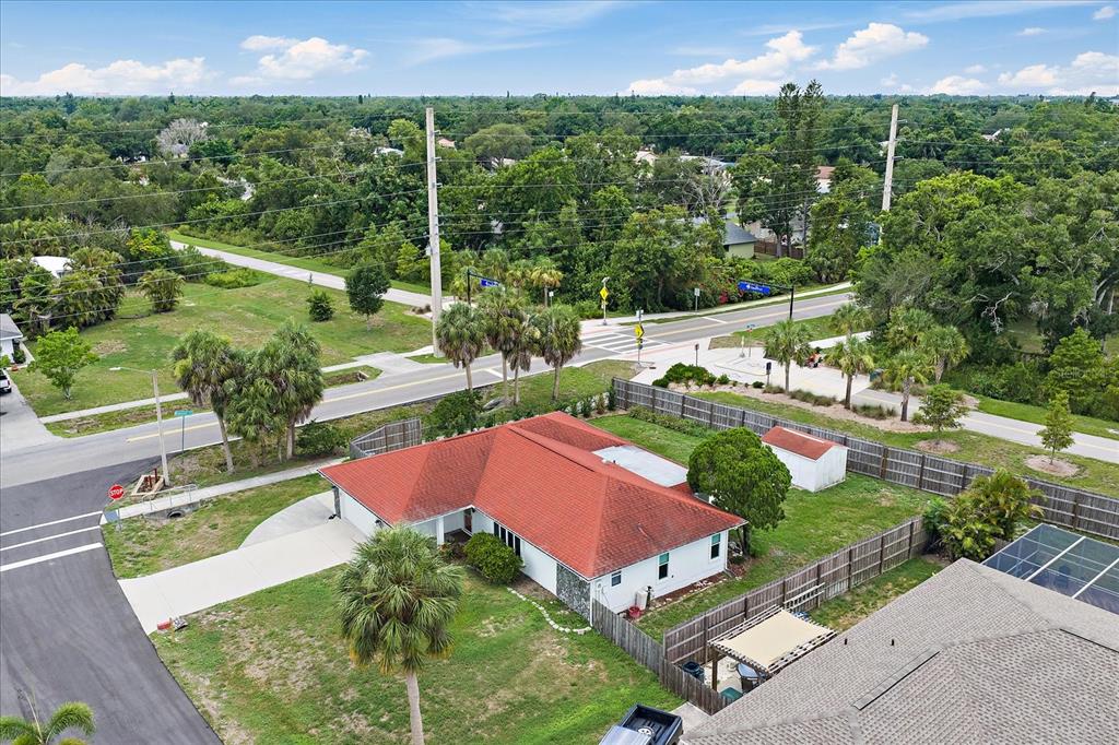An aerial view shows a single-story house with a red roof and a fenced yard — 4378 MEADOWLAND CIRCLE, SARASOTA, FL